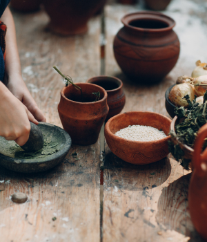 woman-grinds-grass-with-pestle-mortar 1